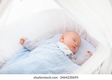 Adorable baby in crib in white sunny bedroom. Newborn child relaxing in bed. Nursery for children. Textile and bedding for kids. Family morning at home. New born kid during tummy time with toy bear. - Powered by Shutterstock