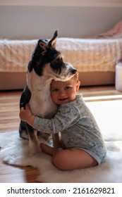 Adorable Baby And Cute Dog On Faux Fur Rug At Home