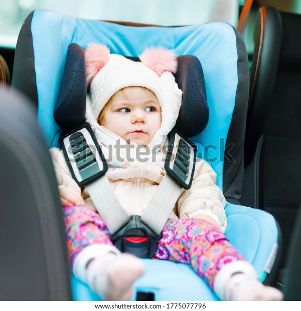 Adorable baby\
girl with blue eyes sitting in car seat. Toddler child in winter\
clothes going on family vacations and jorney. Safe travel, children\
safety, transportation\
concept