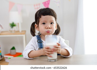 Adorable Baby Girl Dringking Milk With The Glass