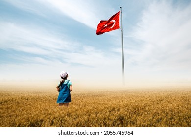 Adorable baby girl is in a field with fog and looking to Turkish national flag admiringly. - Shutterstock ID 2055745964
