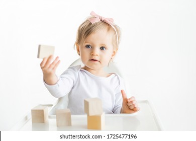 Adorable Baby Girl Playing Colorful Logical Toys In Kindergarten. Toddler Sitting At The Table Isolated On White Background.