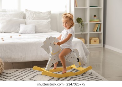 Adorable Baby Girl With Rocking Horse At Home