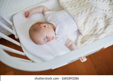 Adorable Baby Girl Sleeping In Co-sleeper Crib Attached To Parents' Bed. Little Child Having A Day Nap In Cot. Sleep Training Concept. Infant Kid In Sunny Nursery