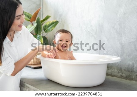 Adorable baby girl taking a bath with mother, family, child, childhood and parenthood concept 