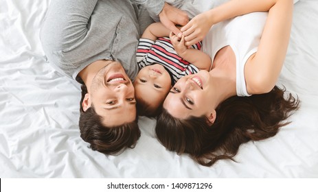 Adorable Baby Lying With Parents, Having Fun In Bed, Upside Down Panorama