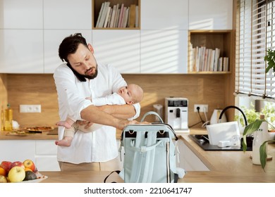 Adorable Baby On Father's Hands Resting.Happy Father Talking On Cell Phone While Holding Baby Packing Rucksack For Going Outside.