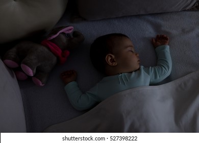 Adorable Baby Sleeping At Night. Little Girl In Pajama Taking A Nap In Dark Room With Toy / Baby Sleeping On The Bed