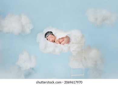 Adorable baby sleeping on clouds in blue sky like little angel.