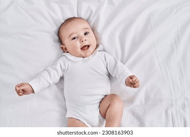 Adorable baby smiling confident lying on bed at bedroom - Powered by Shutterstock