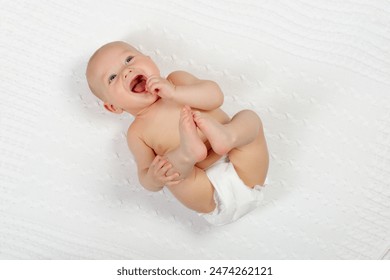 Adorable baby in white sunny bedroom. Newborn child relaxing in bed. Nursery for young children. Textile and bedding for kids. Family morning at home. New born kid during tummy time with toy bear. - Powered by Shutterstock