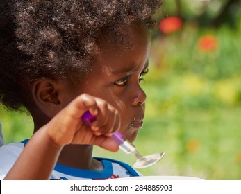 Adorable Black African Baby Eating With Food Full Face