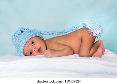 Adorable black baby awake with blue knitted hat