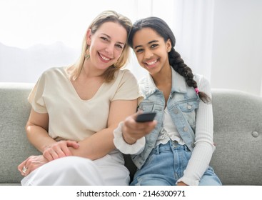 Adorable Black Twin Teen Girl With Mother On Studio White Background Holding Remote Control