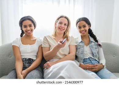 Adorable Black Twin Teen Girl With Mother On Studio White Background Holding Remote Control