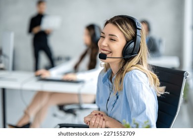 Adorable blond haired woman with headset chatting with customer at call center. - Powered by Shutterstock