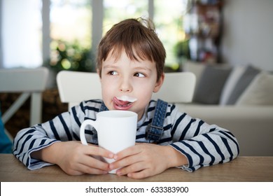 Bé trai đáng yêu uống sữa hoặc sữa chua, độ sâu trường nông