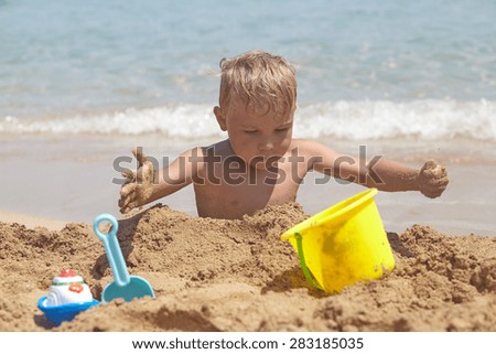 Similar – Image, Stock Photo Small child buried in the sand of the beach