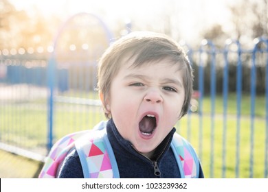 Adorable Boy With Yawning And Look Tired After Playing With Friends In Retro Tone, Tried Child Standing At Playground And Looking At The Camera With A Big Yawn In Sunny Day,Children Activities Concept