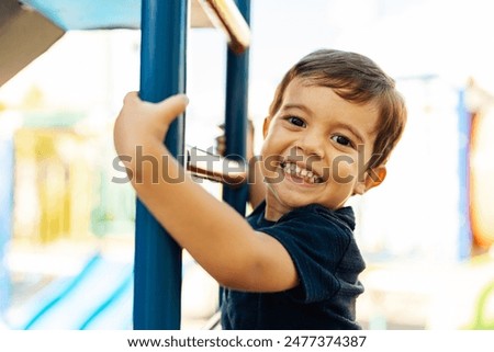 Similar – Image, Stock Photo Cute preschool boy is playing on the ice of a frozen lake or river on a cold sunny winter sunset. Child having fun with icicle and dry reed plant during family hiking. Kids outdoor games