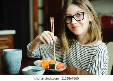 Adorable Brunette Kid Girl In Glasses Eating Sushi