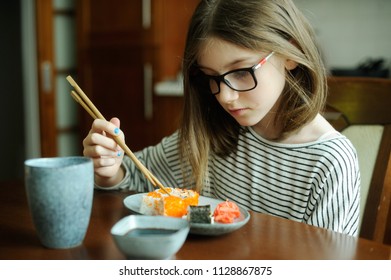 Adorable Brunette Kid Girl In Glasses Eating Sushi