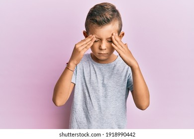 Adorable Caucasian Kid Wearing Casual Clothes With Hand On Head, Headache Because Stress. Suffering Migraine. 