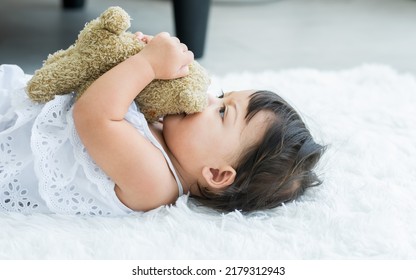 Adorable Caucasian Little Baby Daughter Kid Girl, Laughing, Smiling With Happiness, Good Health, Relax Day Sleeping, Laying Down Alone With Lullaby, Hugging, Playing Bear Doll On White Bed At Home