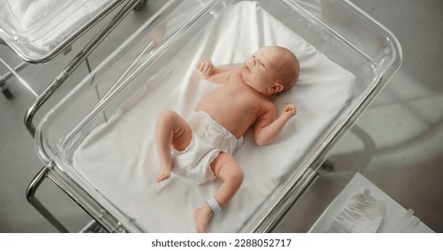 Adorable Caucasian Newborn Child Lying in Hospital Bed in a Nursery Clinic. Little Playful and Healthy Baby. Medical Health Care, Maternity and Parenthood Concept - Shutterstock ID 2288052717