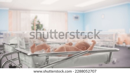 Adorable Caucasian Newborn Child Lying in Hospital Bed in a Nursery Clinic. Little Playful and Healthy Baby. Medical Health Care, Maternity and Parenthood Concept