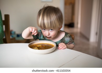 Adorable caucasian toddler boy eating healthy soup in the kitchen, lifestyle real interior - Powered by Shutterstock