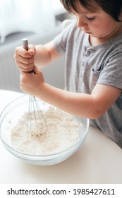 Adorable Cheerful Boy, Kid Is Kneading Dough In The Kitchen. Children Kittens Dough At Home. Real Life Moments