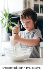 Adorable Cheerful Boy, Toddler Kneads Dough In The Kitchen. Children Cat Dough At Home. Real Life Moments