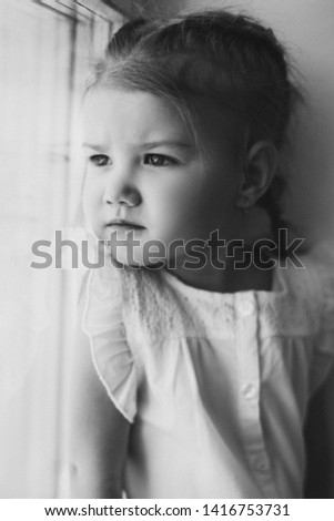 Adorable child with braid holding arms crossed on chest.