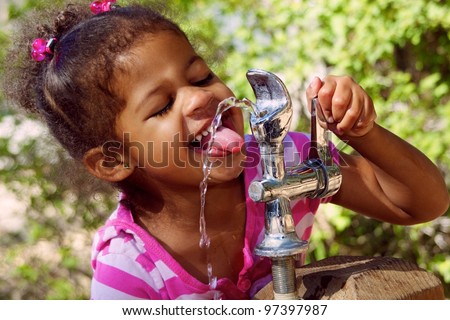 Adorable Child Drinking From Outdoor Water Fountain