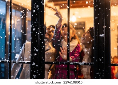 Adorable child looking at the window and first snow flakes with family. Young kid girl sitting in living room at home, watch snow falling outside enjoy celebrate Christmas, Thanksgiving with parents. - Powered by Shutterstock