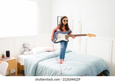 Adorable Child Playing In Her Bedroom And Dreaming To Become A Famous Singer And Musician 