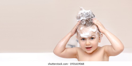 Adorable Child With Shampoo Foam And Bubbles On Hair Taking Bath. Portrait Of Smiling Kid, Health Care And Hygiene Concept. Washes Hair By Herself. Banner, Mock Up, Place For Text.White And Biege