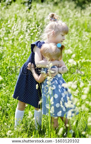 Similar – A boy and a girl in toddlerhood are standing on a log in summer clothes