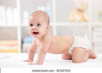 Adorable crawling baby weared diaper on white blanket at home