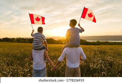 Adorable cute Caucasian boys holding Canadian flag on the father shoulder