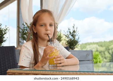 Adorable cute Caucasian brown haired girl sipping fresh tasty cocktail at cafe looking at camera with satisfied facial expression resting in restaurant - Powered by Shutterstock