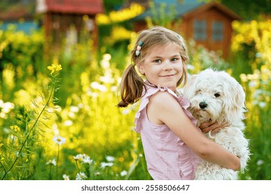 Adorable cute little girl and her puppy on the nature in the summer. Happy school child with eyeglasses holding Maltese dog, having fun with playing. Bright sunset light, active kid. - Powered by Shutterstock