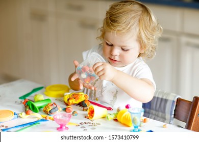 Adorable Cute Little Toddler Girl With Colorful Clay. Healthy Baby Playing And Creating Toys From Play Dough. Small Kid Molding Modeling Clay And Learning