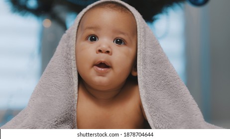 Adorable Dark Skin Baby Covered With Towel Having Fun Tummy Time. High Quality Photo