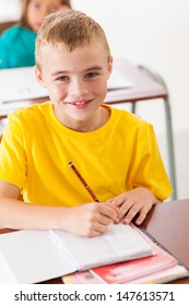 Adorable Elementary Student In Classroom Writing Classwork