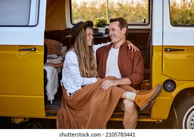 Adorable Family Couple Sit In Van Having Rest After Road Trip, In Contryside. Caucasian Lovely Adult Man And Woman In Nature, Posing At Camera, In Love, Happy Spend Summer Days Together
