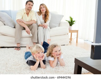 Adorable family watching tv in the living room