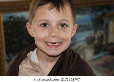 Adorable Five Year Old Boy With Brown Hair And Big Blue Eyes Look At The Camera Smiling In A Close Up Picture.  He Is Missing His Two Front Teeth.