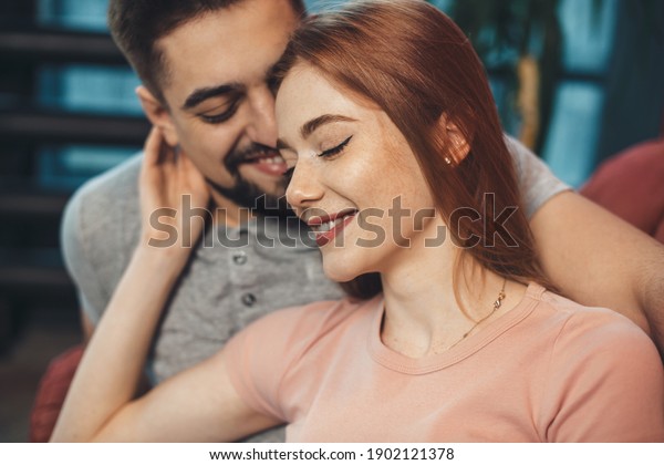 Adorable ginger woman with freckles is\
embracing her lover while dating on valentines\
day